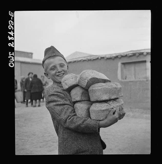 کودک خندان لهستانی در اردوگاه آوارگان جنگی تهران نانهایش را در آغوش گرفته  ۱۹۴۳